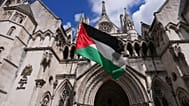 متظاهر يلوّح بعلم فلسطين خارج المحكمة العليا في لندن، يوم الإثنين، 21 يوليو 2025.