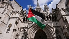 متظاهر يلوح بعلم خارج المحكمة العليا، لندن حيث تُعقد جلسة استماع كاملة بشأن طلب المراجعة القضائية الذي تقدمت به منظمة "فلسطين أكشن" ضد حظرها الوشيك، الاثنين 21 يوليو/تموز 2025
