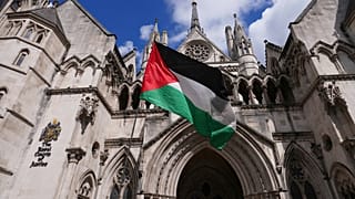 متظاهر يلوح بعلم خارج المحكمة العليا، لندن حيث تُعقد جلسة استماع كاملة بشأن طلب المراجعة القضائية الذي تقدمت به منظمة "فلسطين أكشن" ضد حظرها الوشيك، الاثنين 21 يوليو/تموز 2025