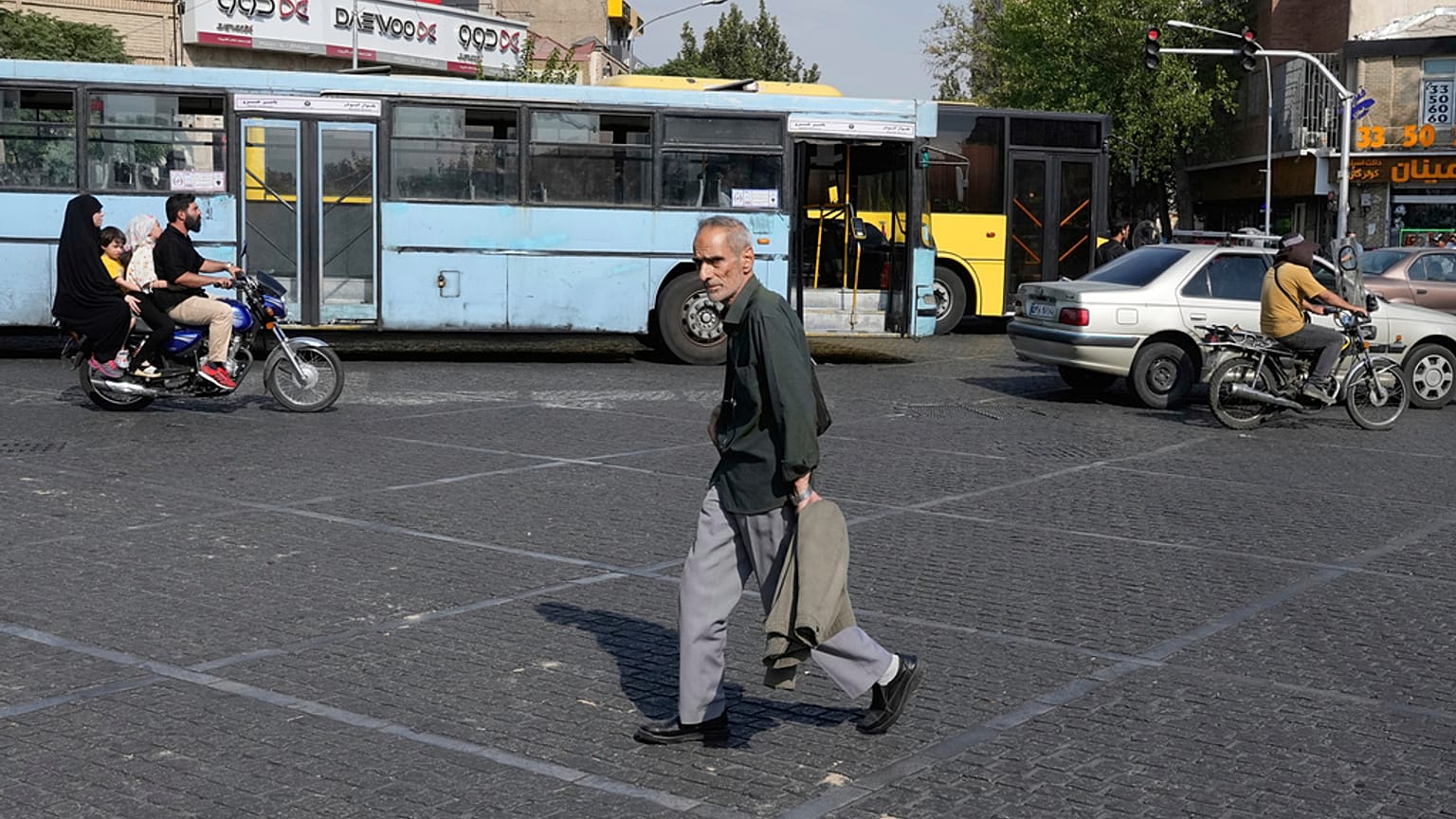 Tahran şehir merkezinde bir adam karşıdan karşıya geçerken, 21 Temmuz 2025