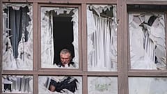 مردی پس از حمله روسیه در کی‌یف، اوکراین، دوشنبه، ۲۱ ژوئیه ۲۰۲۵، کنار پنجره‌های شکسته خانه‌اش ایستاده است.