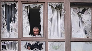 مردی پس از حمله روسیه در کی‌یف، اوکراین، دوشنبه، ۲۱ ژوئیه ۲۰۲۵، کنار پنجره‌های شکسته خانه‌اش ایستاده است.
