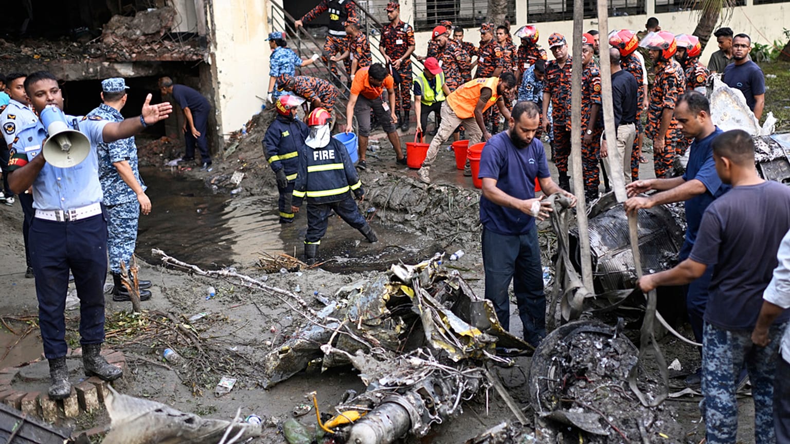 Bombeiros no local da queda de um avião militar numa escola do Bangladesh