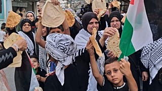فلسطينيون يحملون قطعًا من الخبز خلال احتجاج في مخيم عين الحلوة للاجئين في مدينة صيدا الساحلية الجنوبية بلبنان، الأحد 20 يوليو/تموز 2025. 