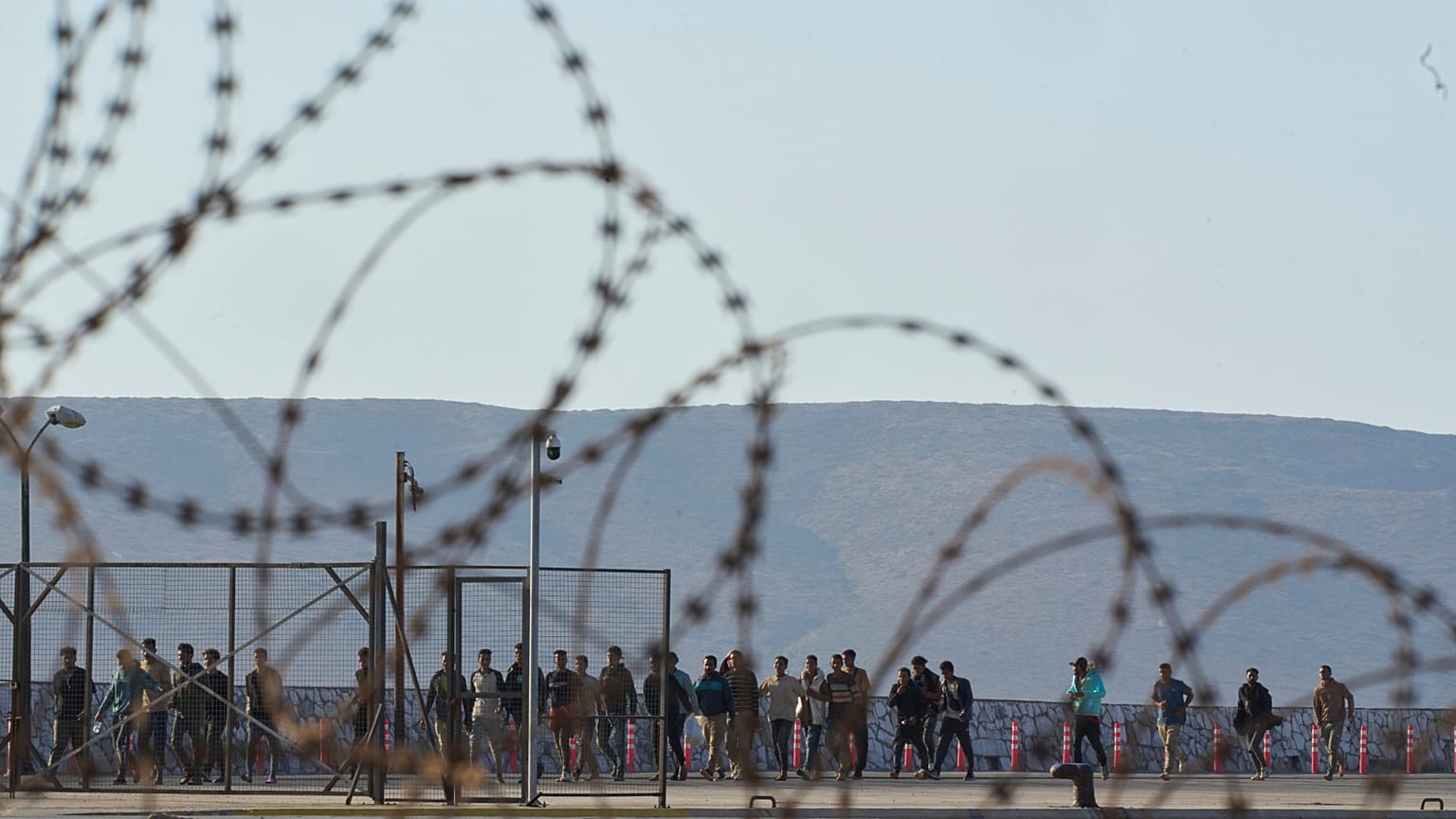 Migrantes rescatados al sur de Creta caminan tras su llegada al puerto de Lavrio, Grecia, el jueves 10 de julio de 2025.