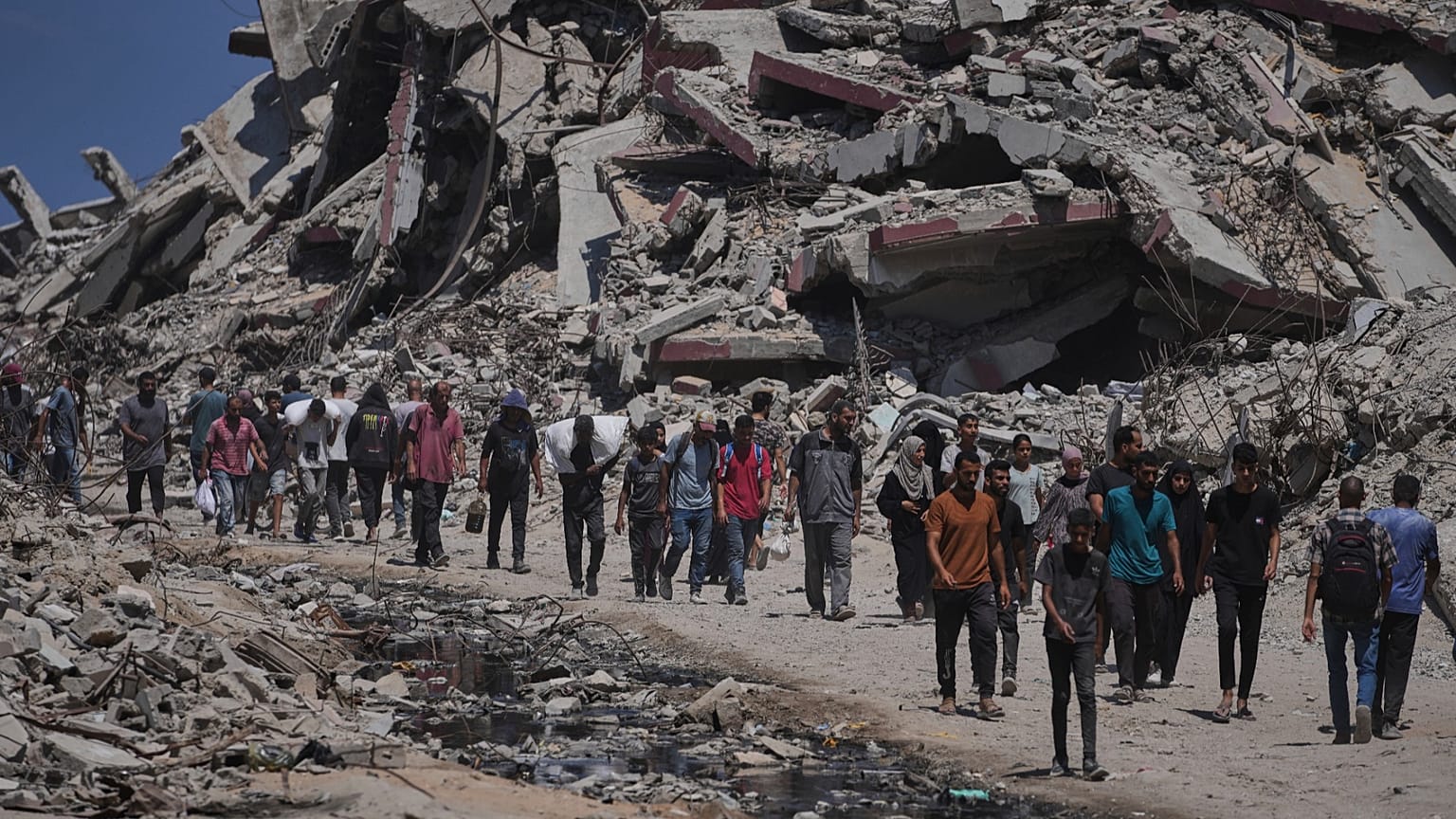 Palestinians carry sacks of flour unloaded from a humanitarian aid convoy that reached Gaza City from the northern Gaza Strip, 22 July, 2025