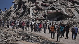 Palestinians carry sacks of flour unloaded from a humanitarian aid convoy that reached Gaza City from the northern Gaza Strip, 22 July, 2025