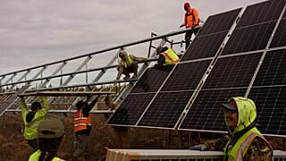 Des ouvriers installent des panneaux dans le cadre d'un projet solaire à Galena, en Alaska.