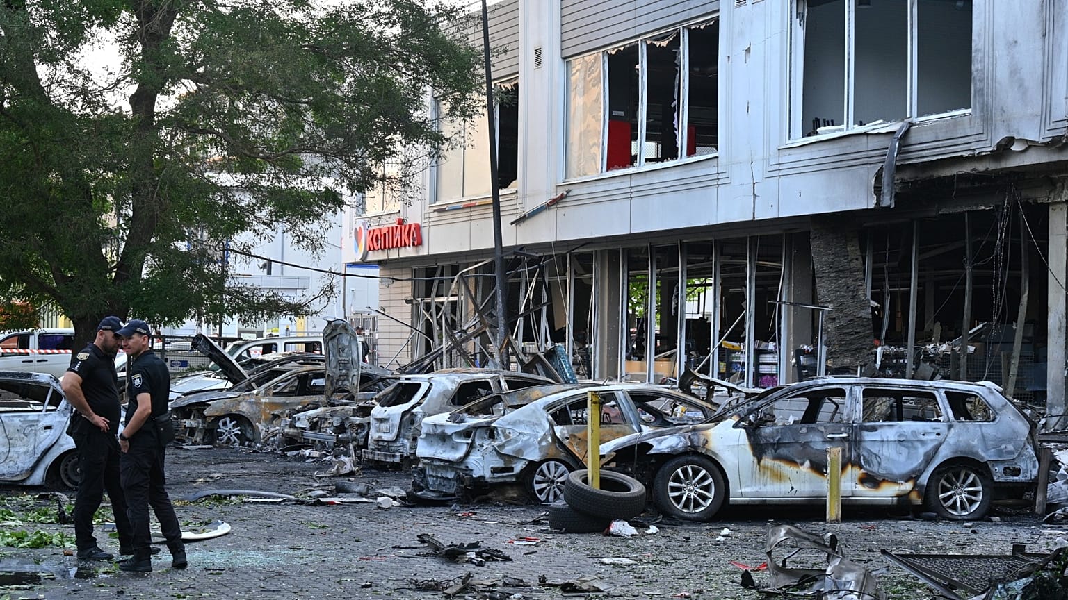 Αστυνομικοί επιθεωρούν κατεστραμμένα αυτοκίνητα σε κατοικημένη περιοχή μετά την επίθεση με μη επανδρωμένα αεροσκάφη της Ρωσίας στην Οδησσό της Ουκρανίας, Τρίτη 22 Ιουλίου 2025. 