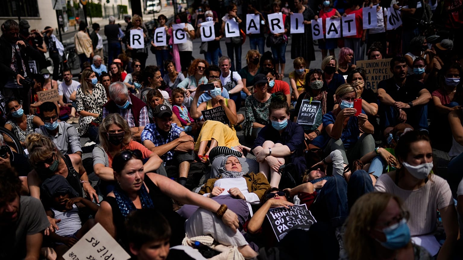 People listen to speeches during a protest in support of migrants without officials papers on hunger strike in Brussels, 17 July, 2021