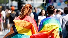 Pessoas envoltas em bandeiras do arco-íris participam no desfile do Orgulho LGBTQ+ em Roma, 10 de junho de 2023