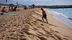Un bañista camina por la orilla de una playa de Barcelona, España.