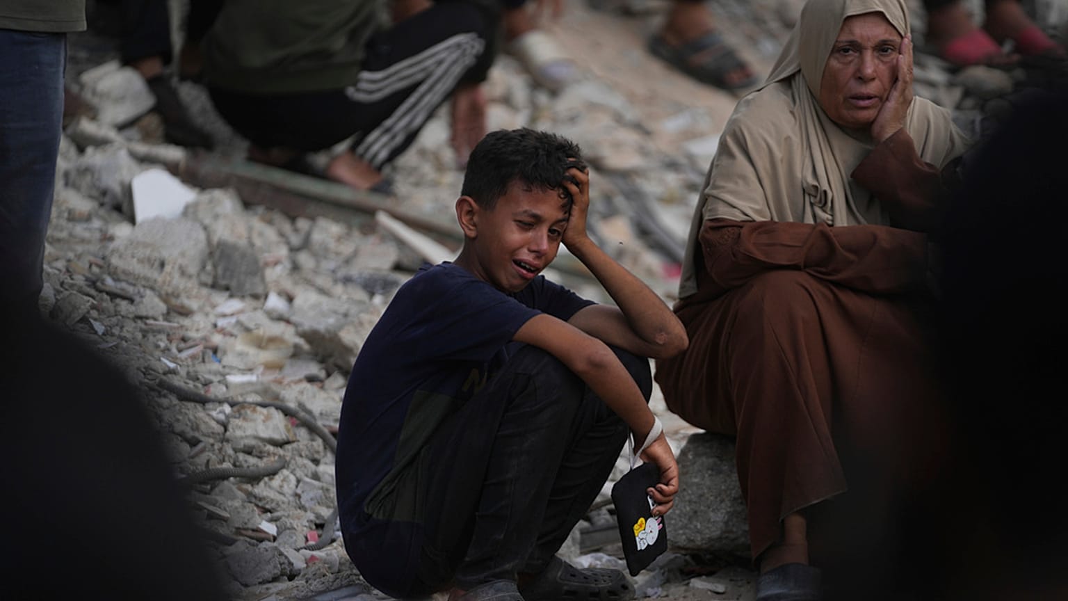 Palestinianos choram no funeral de pessoas mortas quando tentavam chegar a camiões de ajuda humanitária que entravam no norte de Gaza através do cruzamento de Zikim com Israel, no Hospital Shifa, em Gaza, sábado, 26 de julho de 2025