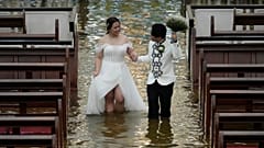 Das frisch verheiratete Paar Jade Rick Verdillo und Jamaica schreitet Hand in Hand während ihrer Hochzeit in der überfluteten Barasoain-Kirche in Malolos, Provinz Bulacan, Philippinen, am 22. Juli 2025.