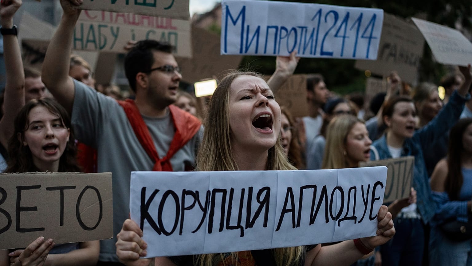 Une femme scande des slogans en tenant une banderole sur laquelle on peut lire « La corruption applaudit », lors d'une manifestation contre une loi visant les institutions anti-corruption à Kyiv, Ukraine, le 22 juillet 2025.