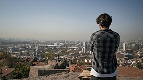 A man looks over a smoggy city.