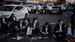 Ultraorthodoxe jüdische Männer blockieren am Mittwoch, den 23. Juli 2025, während eines Protests gegen die Wehrpflicht den Verkehr in Jerusalem.