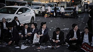 Varios hombres judíos ultraortodoxos bloquean el tráfico durante una protesta contra el reclutamiento militar en Jerusalén, miércoles, 23 de julio de 2025