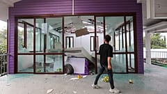 I thailandesi osservano i danni causati all'ospedale Phanom Dong Rak dopo che la Cambogia ha lanciato colpi di artiglieria sulla provincia di Surin, in Thailandia, 24/07/2025
