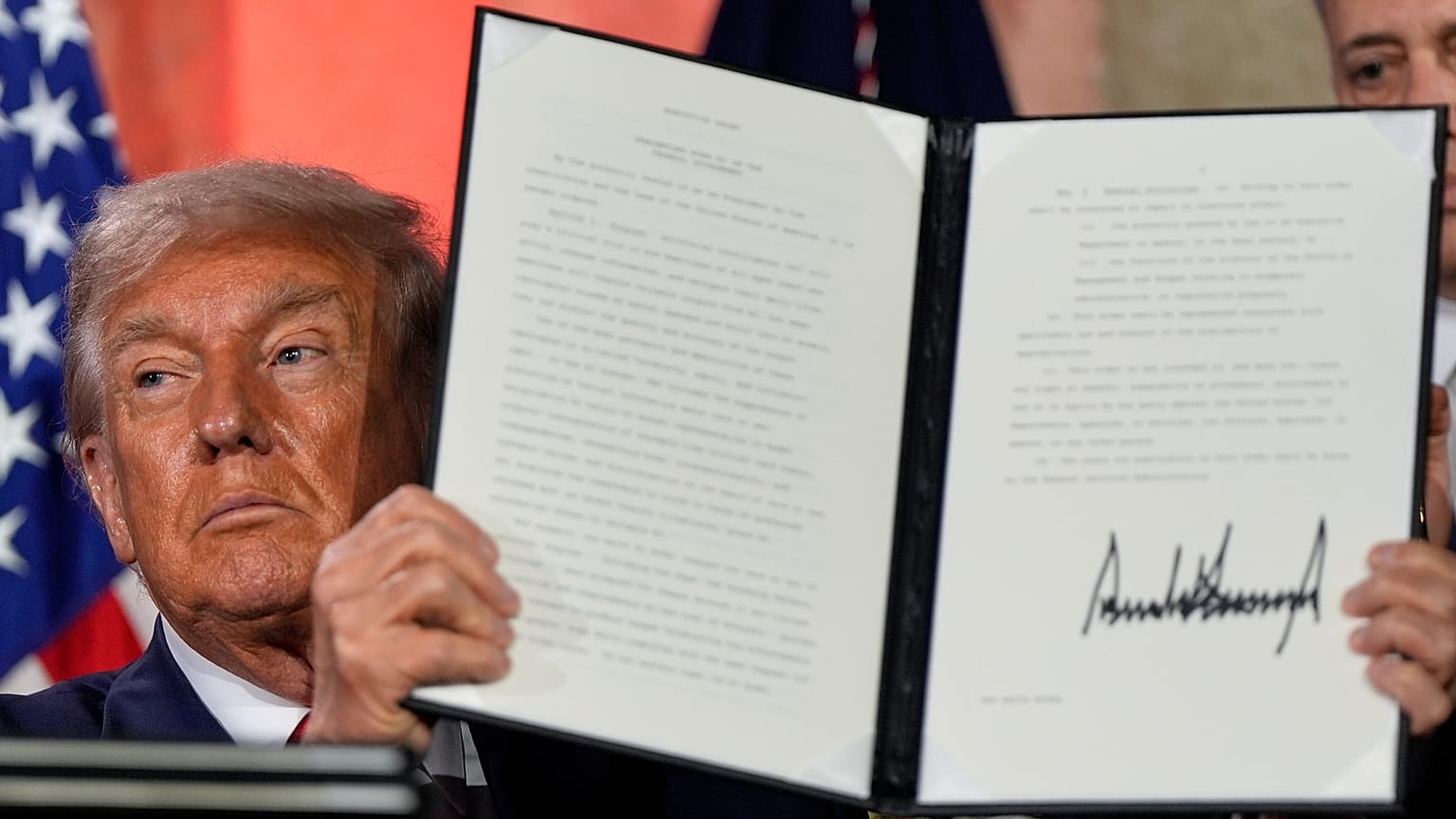 President Donald Trump holds a signed executive order after speaking during an AI summit at the Andrew W. Mellon Auditorium, Wednesday, July 23, 2025, in Washington. 