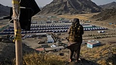  یک عضو طالبان در ۳۱ مه ۲۰۲۵، در گذرگاه مرزی تورخم، افغانستان، مشرف به اردوگاه پناهندگان افغانِ بازگردانده شده از پاکستان 
