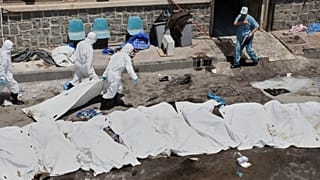 عمال المشرحة يضعون جثث أشخاص مجهولي الهوية قتلوا خلال الاشتباكات بين عشائر البدو والدروز، في أكياس بلاستيكية خارج المستشفى الوطني في السويداء، سوريا، الاثنين 21 يوليو/ تموز.