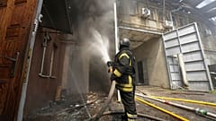 Feuerwehrleute bekämpfen den Brand nach einem russischen Angriff, der ein Wohngebiet in Charkiw getroffen hat.