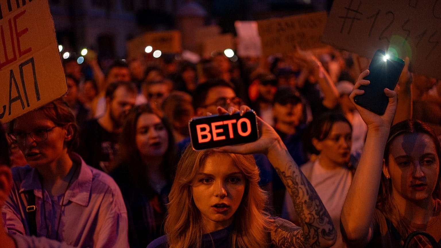 Kobieta trzyma telefon z tabliczką z napisem "Weto" podczas protestu przeciwko ustawie dotyczącej regulacji instytucji antykorupcyjnych w centrum Kijowa, 22 lipca 2025 roku.
