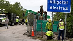 Operai installano un cartello all'ingresso di un nuovo centro di detenzione per migranti presso il Dade-Collier Training and Transition, a Ochopee, Florida, 3 luglio 2025