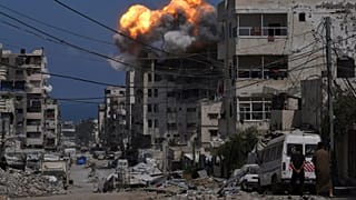 Füst és lángok csapnak fel egy izraeli légicsapás után Gázavárosban, 2025. július 21-én