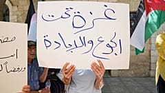 نشطاء فلسطينيون يشنون حملة إضراب عن الطعام ، تحمل لافتة كتب عليها "غزة تحت الجوع والإبادة" ، في مدينة رام الله بالضفة الغربية ، الخميس 24 تموز / يوليو 2025.