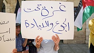 نشطاء فلسطينيون يشنون حملة إضراب عن الطعام ، تحمل لافتة كتب عليها "غزة تحت الجوع والإبادة" ، في مدينة رام الله بالضفة الغربية ، الخميس 24 تموز / يوليو 2025.