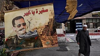 A shoe hangs on a portrait of ousted Syrian President Bashar al-Assad in Damascus, 23 December, 2024