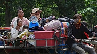 Kambodschaner sitzen auf einem Traktor, als sie im Wat Tham Kambar in der Provinz Oddar Meanchey, Kambodscha, Zuflucht suchen, Freitag, 25. Juli 2025.