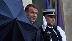 O Presidente francês Emmanuel Macron segura um guarda-chuva no Palácio do Eliseu em Paris, 24 de julho de 2025 