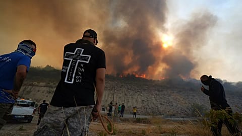 Residents gather to battle the fire at Omodos village, 24 July 2025