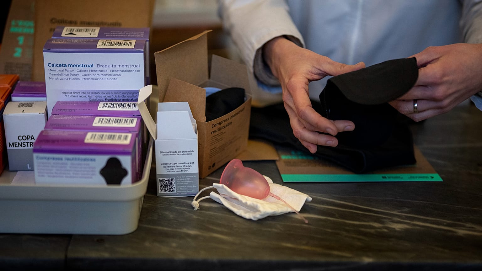 A pharmacist prepares an underwear for periods next to other items free of charge, at a pharmacy in Barcelona, Spain, Tuesday, March 5, 2024. 