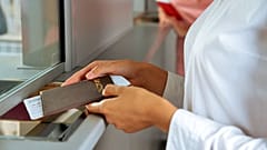 Una mujer con su pasaporte en el mostrador de inmigración de un aeropuerto. 