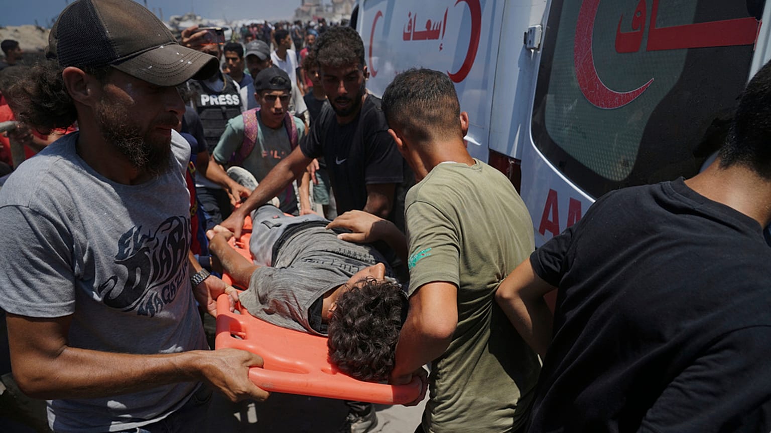 يتم نقل جرحى فلسطينيين إلى سيارة إسعاف بعد إصابتهم أثناء انتظار وصول المساعدات من شمال قطاع غزة