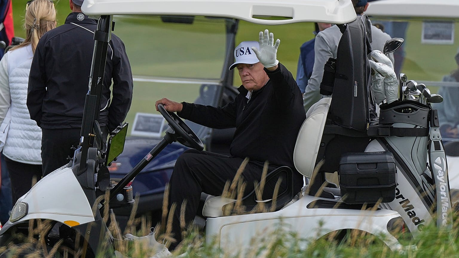 Präsident Donald Trump winkt Reportern zu, während er in seinem Golfwagen auf dem Trump Turnberry Golfplatz in Turnberry, Schottland, sitzt, Samstag, 26. Juli 2025.