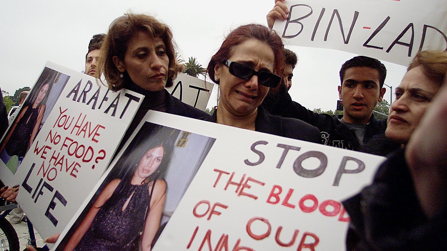 Εικόνα αρχείου - Heftziba Hazzout, middle wearing glasses, cries as she asks: "Why,?" while holding a photo of her niece, Rachel Levi, 