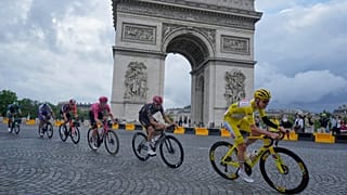 O esloveno Tadej Pogacar, com a camisola amarela, passa pelo Arco do Triunfo na última etapa da Volta a França de 2025, a 27 de julho de 2005.