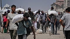 Palästinenser tragen Mehlsäcke, die von einem humanitären Hilfskonvoi abgeladen wurden, der Gaza-Stadt aus dem nördlichen Gazastreifen erreichte, Sonntag, 27. Juli 2025. 