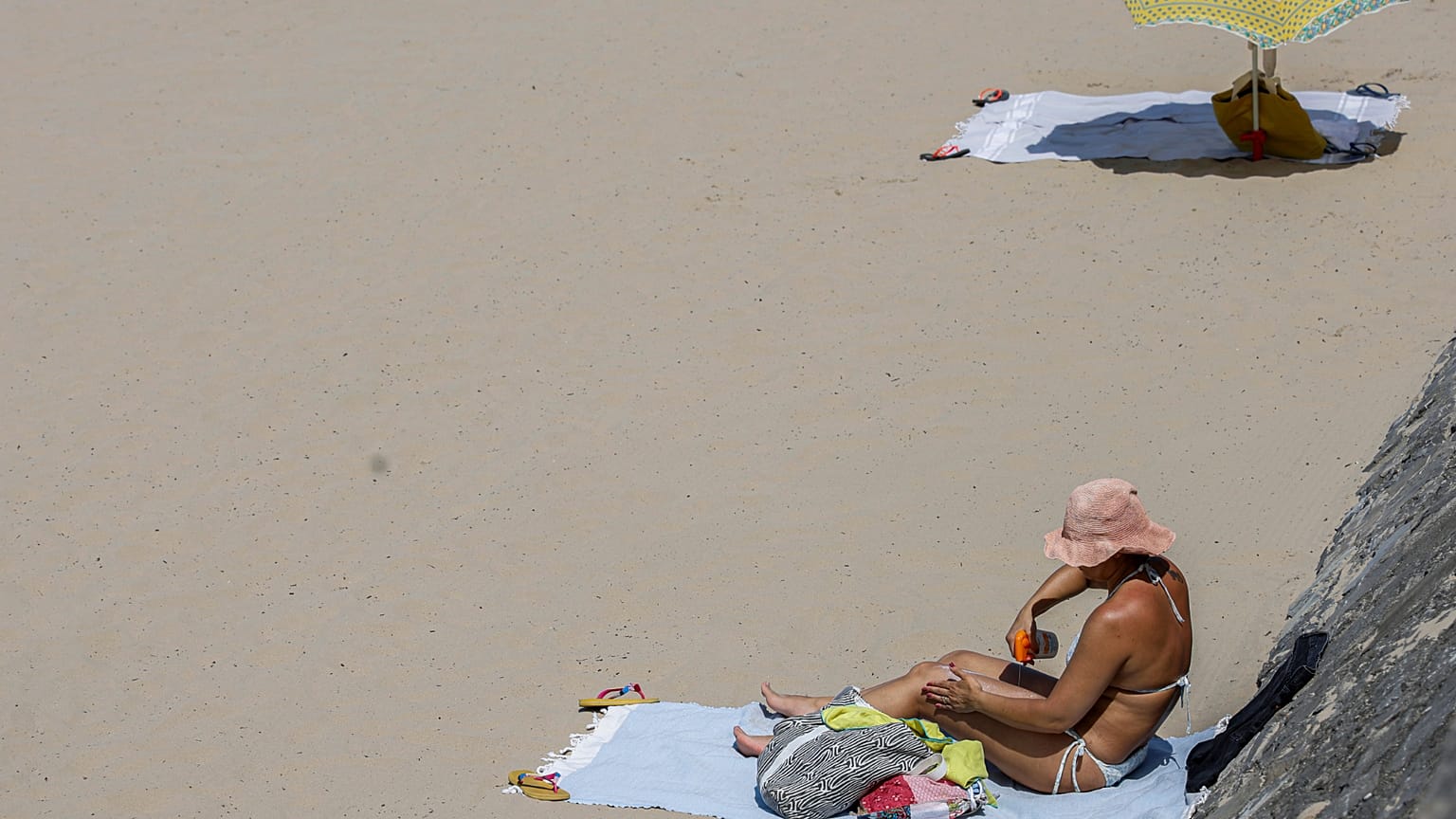 Egy nő naptejet használ 2025. június 30-án, hétfőn a délnyugat-franciaországi Hendaye strandján. 