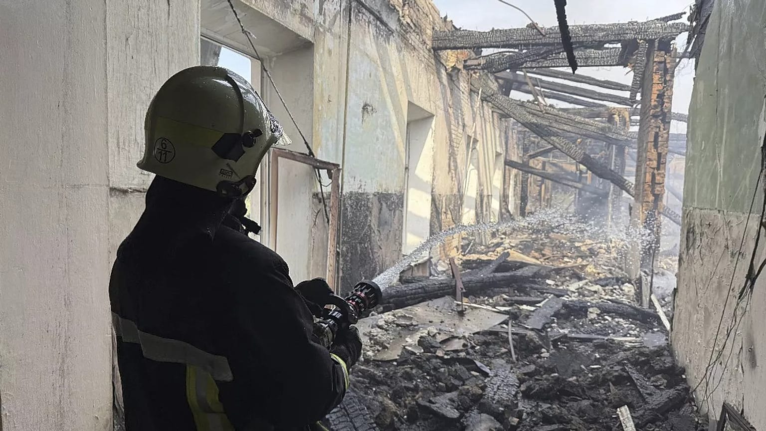 Bombeiros apagam o fogo numa escola do corpo de bombeiros após um ataque aéreo russo em Kropyvnytskyi, 28 de julho de 2025