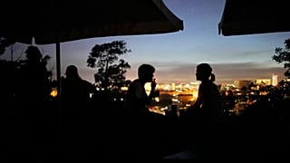 ARQUIVO - Pessoas sentadas no terraço de um bar fechado no miradouro do Monte Agudo, com vista para Lisboa, durante uma falha de energia em todo o país, 28 de abril