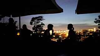 People sit on the terrace of a closed bar at the Monte Agudo viewpoint overlooking Lisbon during a nationwide power outage, 28 April, 2025