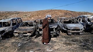 فلسطيني يتفقد ساحة الخردة التابعة له، حيث احترقت المركبات خلال هجوم شنه مستوطنون إسرائيليون ليلًا.