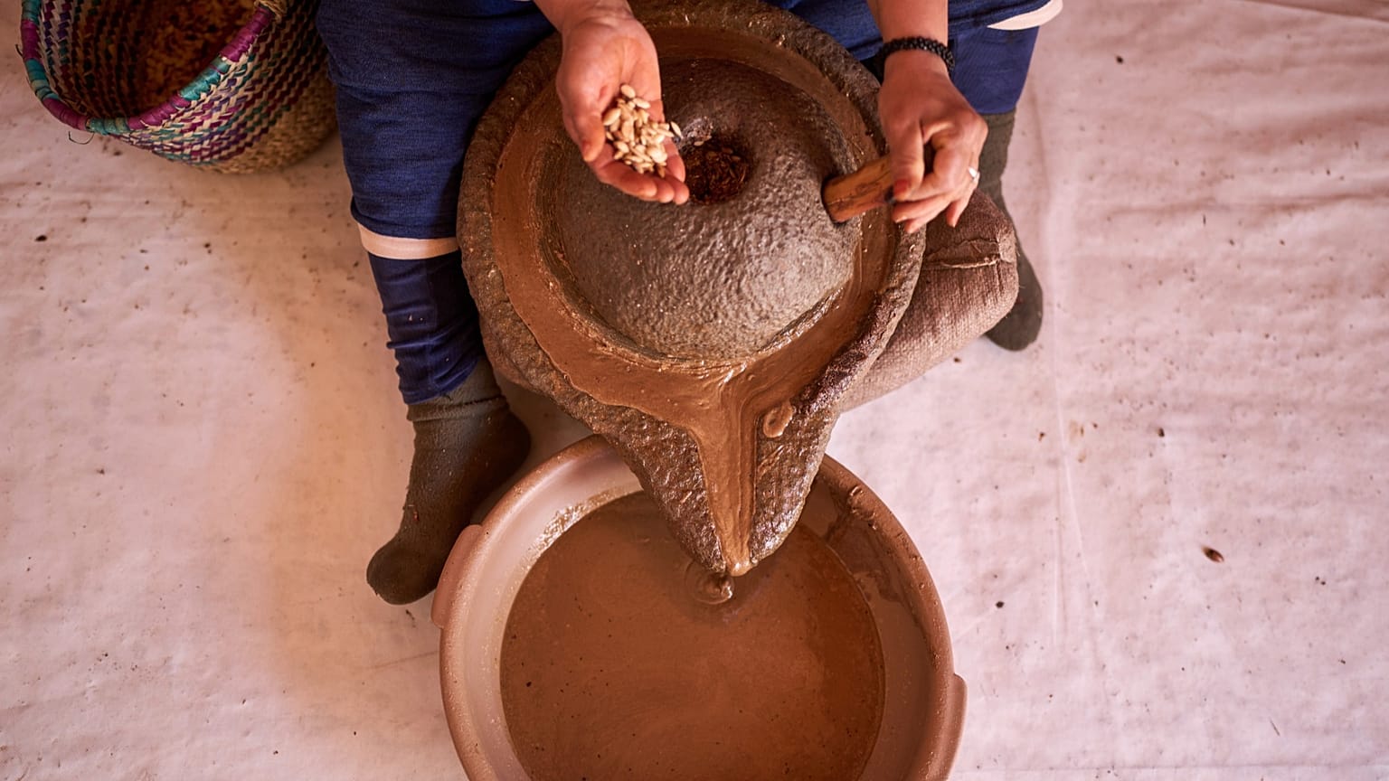 Una donna versa le noci di argan per estrarre l'olio in una cooperativa di Essaouira, in Marocco.