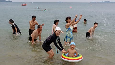 Люди наслаждаются купанием в море на курорте Вонсан-Кальма